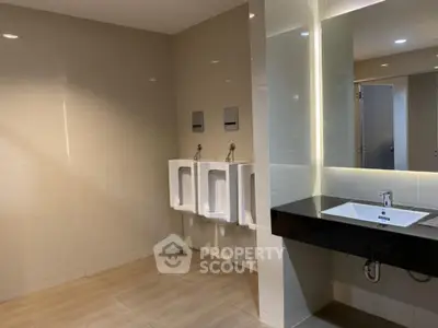 Modern public restroom with sleek urinals and stylish sink area.
