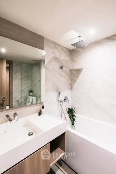 Modern bathroom with sleek design, featuring a bathtub and elegant fixtures.