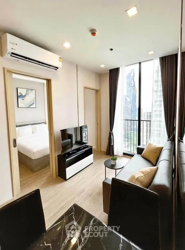 Modern living room with city view, featuring sleek furniture and natural light, perfect for urban living.