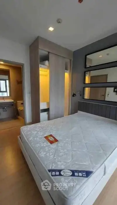 Modern bedroom with stylish decor and ensuite bathroom in a contemporary apartment.