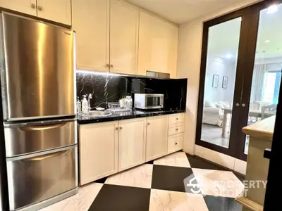 Modern kitchen with sleek appliances and elegant black and white flooring