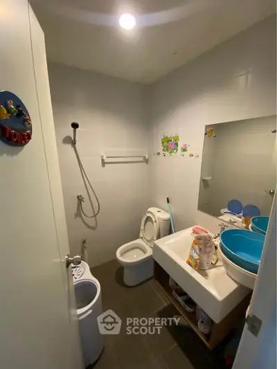 Compact bathroom with modern fixtures and playful decor, ideal for small spaces.