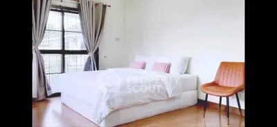 Bright and cozy bedroom with modern decor and large window view.