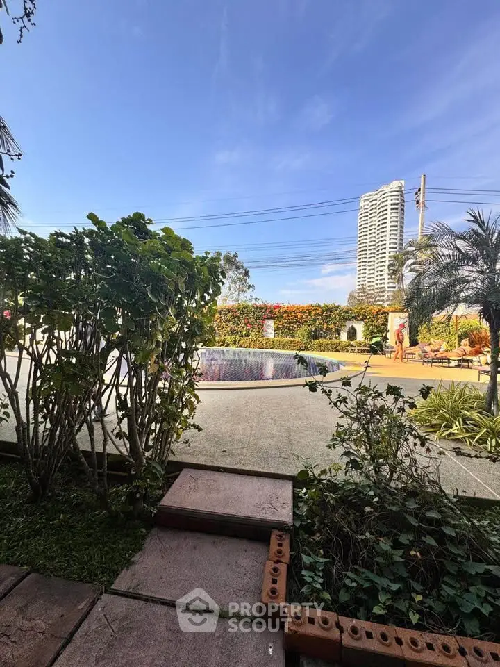 Luxurious high-rise building view with lush garden and pool, perfect for modern living.