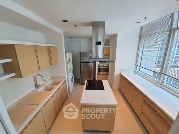 Spacious modern kitchen with island, ample cabinetry, and large windows for natural light.