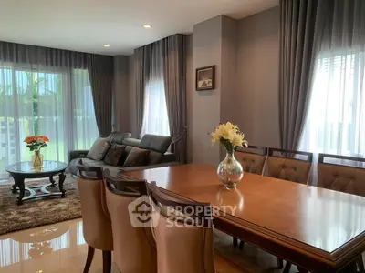 Elegant living room with large windows and stylish furniture, perfect for family gatherings.
