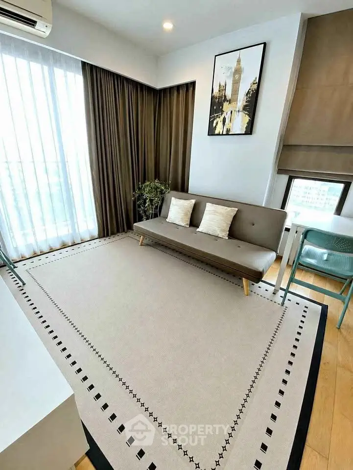 Stylish living room with modern decor and large window for natural light.
