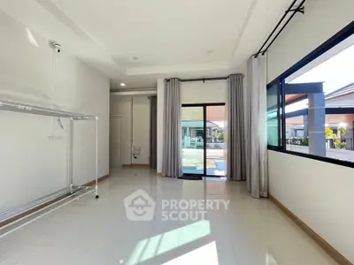 Spacious empty room with large windows and garden view, perfect for customization.