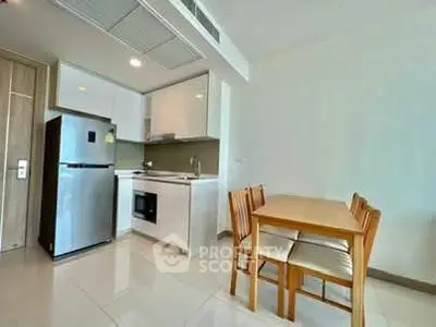 Modern kitchen with dining area, featuring sleek appliances and minimalist design.
