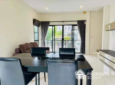 Spacious modern living room with dining area and balcony view