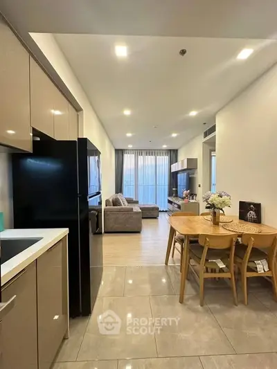 Modern open-layout kitchen and living room with stylish decor and ample natural light.