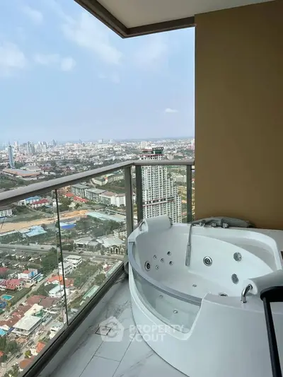 Luxurious balcony with jacuzzi offering stunning city skyline views.