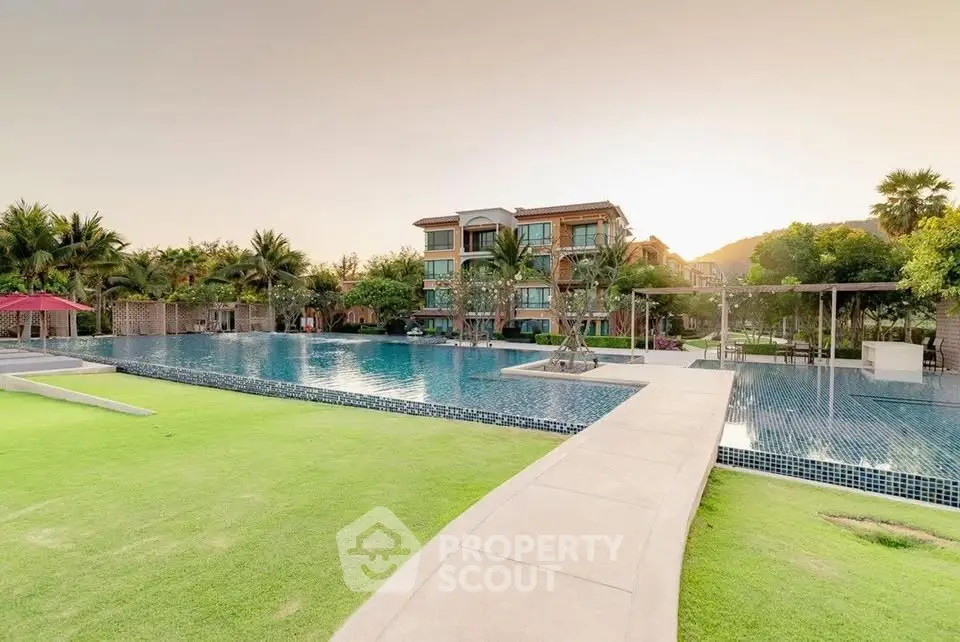 Luxurious apartment complex with stunning pool and lush greenery