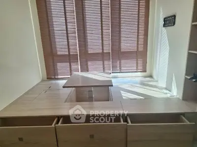 Modern study room with built-in wooden desk and storage, featuring elegant blinds for natural light control.