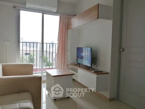 Modern living room with sleek furniture and balcony view, perfect for urban living.
