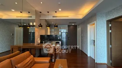 Modern open-layout kitchen and living area with stylish lighting and wooden flooring.