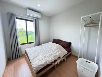 Cozy bedroom with natural light, featuring a comfortable bed and minimalist decor, perfect for relaxation.