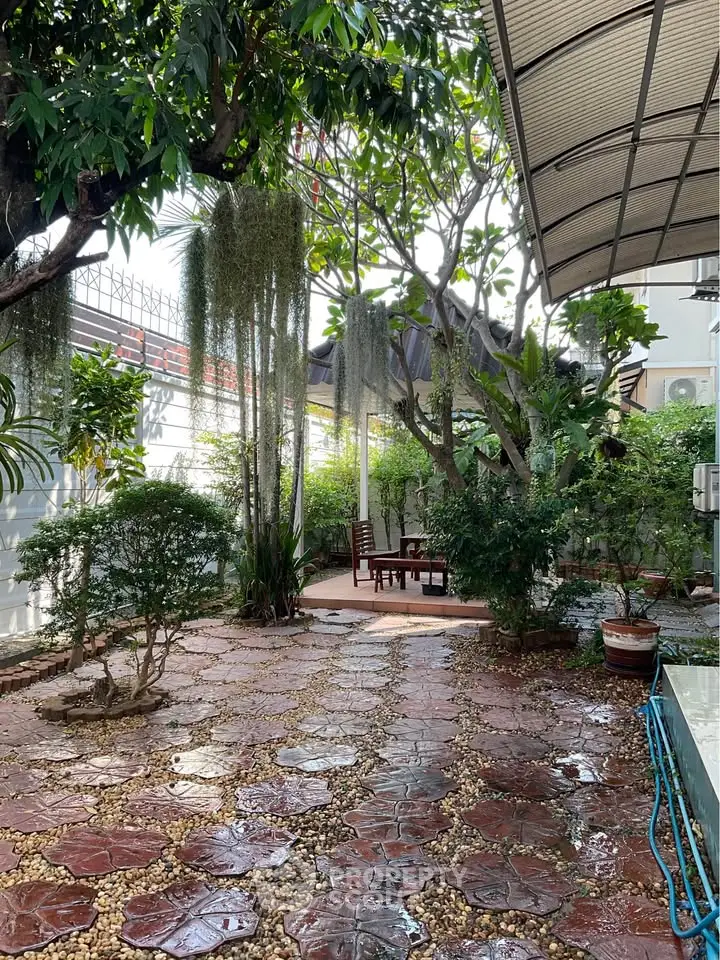 Charming garden oasis with lush greenery and cozy seating area, perfect for relaxation and outdoor gatherings.