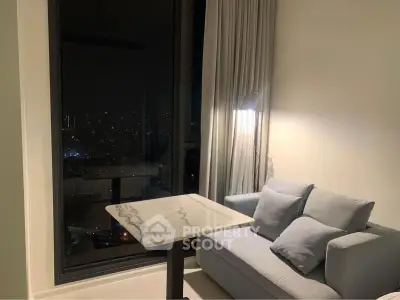 Cozy living room with city view, featuring a modern sofa and marble table, perfect for urban living.