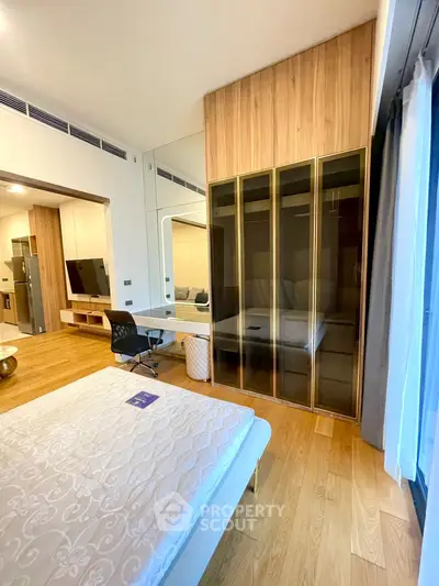 Modern bedroom with wooden flooring, mirrored wardrobe, and stylish decor