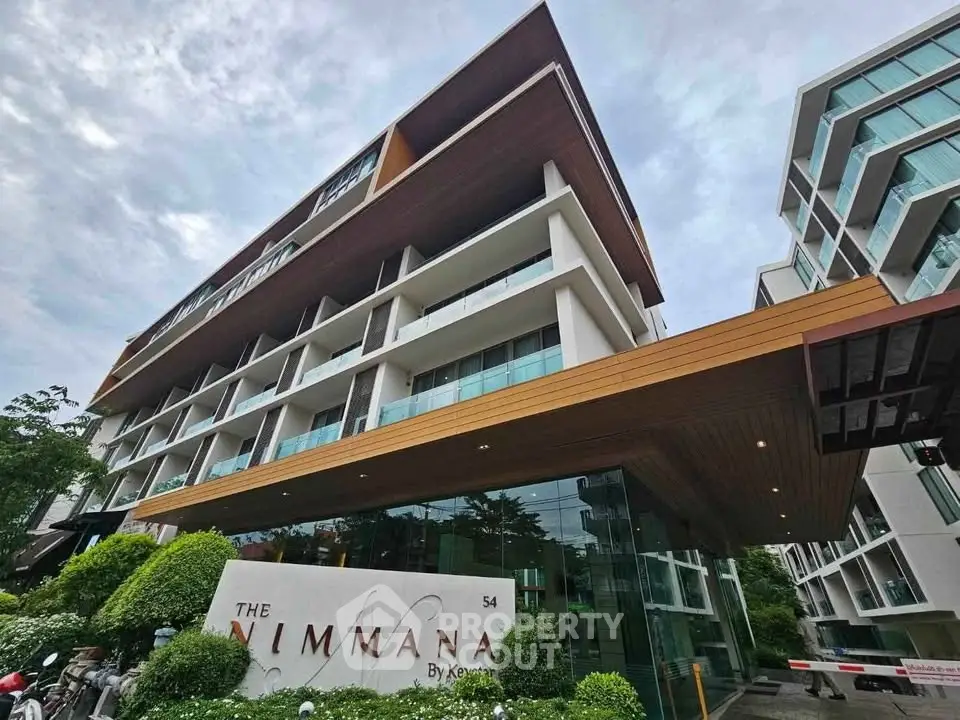 Modern condominium building with sleek architecture and lush greenery at The Nimmana by Keyne.