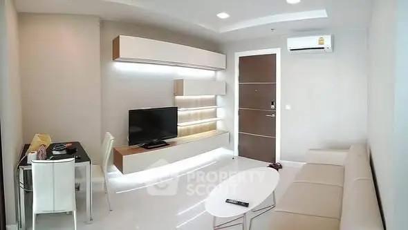 Modern living room with sleek furniture and wall-mounted TV in a stylish apartment.