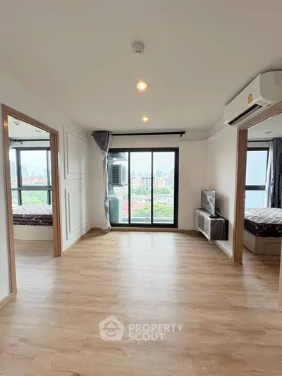 Spacious living room with large windows offering stunning city views in modern apartment.