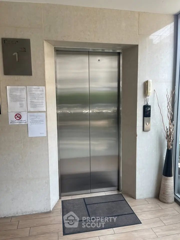 Modern elevator entrance in a stylish building lobby with sleek design.