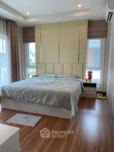 Modern bedroom with elegant design and large windows for natural light.