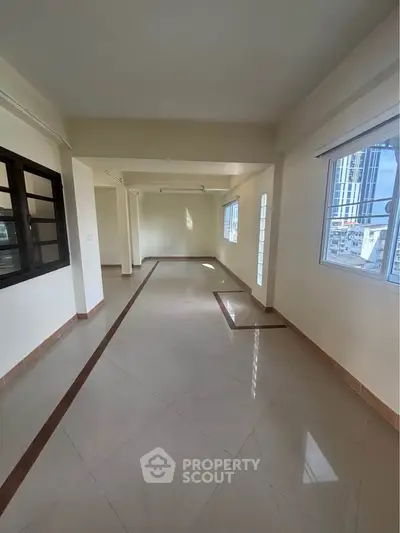 Spacious and bright interior with large windows and tiled flooring, perfect for modern living.