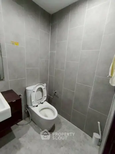 Modern bathroom with sleek gray tiles and contemporary fixtures.
