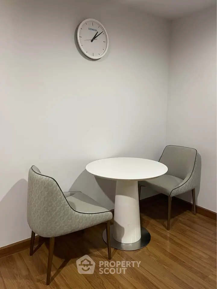 Cozy corner with modern chairs and round table, perfect for intimate conversations.