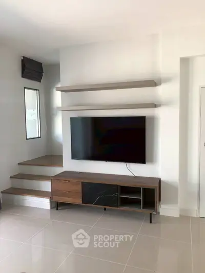 Modern living room with sleek TV setup and stylish shelving, perfect for contemporary homes.
