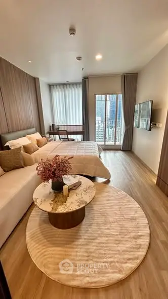 Luxurious bedroom with city view, modern decor, and cozy seating area in high-rise apartment.