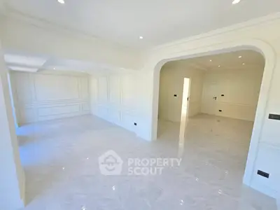 Spacious and elegant interior with marble flooring and classic wall paneling.