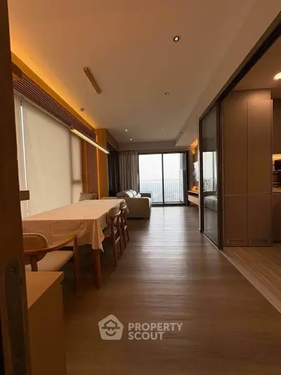 Spacious modern living room with dining area and large windows offering a stunning view.