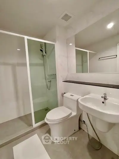 Modern bathroom with sleek shower and elegant fixtures in a contemporary apartment.