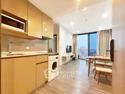 Modern open-plan kitchen and living room with balcony view in high-rise apartment