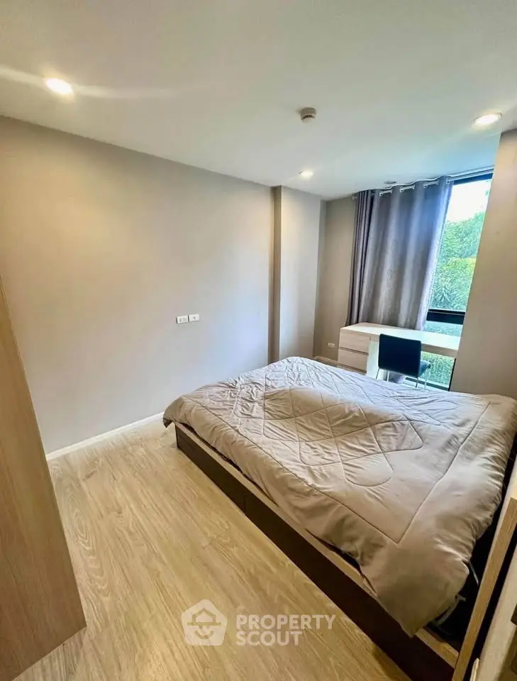 Modern bedroom with large window and stylish decor in a contemporary apartment.