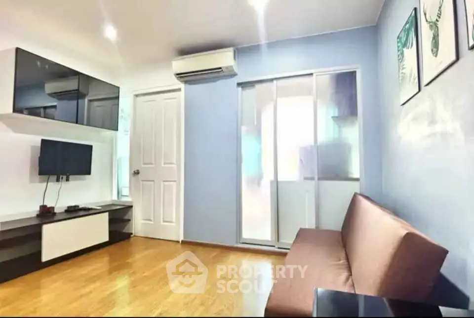 Modern living room with sleek design, featuring a wall-mounted TV and stylish furniture.