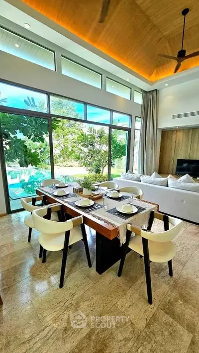 Luxurious open-plan living room with pool view, featuring elegant dining area and modern decor.