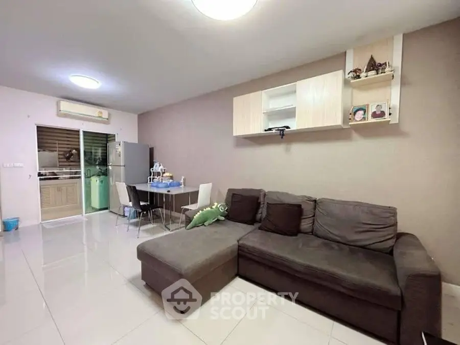 Spacious living room with modern sofa and dining area in open layout apartment.