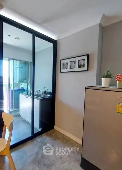 Modern kitchen with sleek glass partition and stainless steel fridge