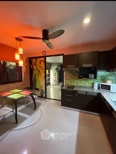 Modern kitchen with sleek cabinets, stylish lighting, and a cozy dining area.