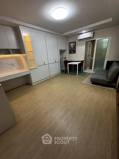 Modern living room with sleek design, featuring built-in cabinets and cozy dining area.
