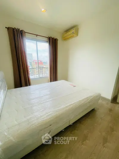 Bright bedroom with large window and air conditioning in modern apartment