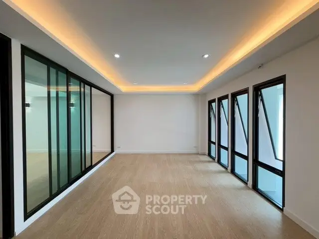 Spacious modern living room with floor-to-ceiling windows and elegant lighting