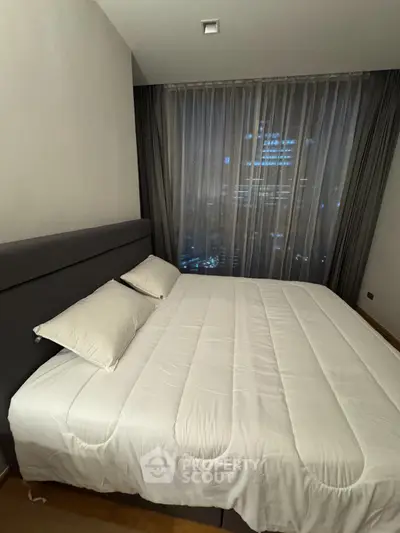 Modern bedroom with city view, featuring a cozy bed and elegant curtains, perfect for urban living.