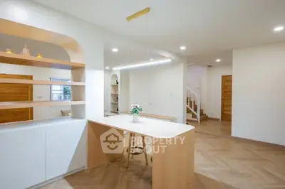 Modern open-plan kitchen with stylish wooden accents and elegant lighting