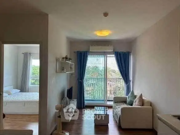 Bright living room with balcony view, modern furniture, and natural light in a cozy apartment.